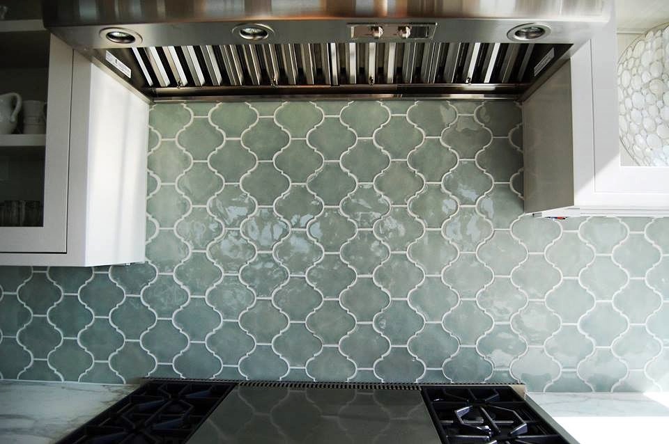 Kitchen with arabesque tile backsplash and range hood