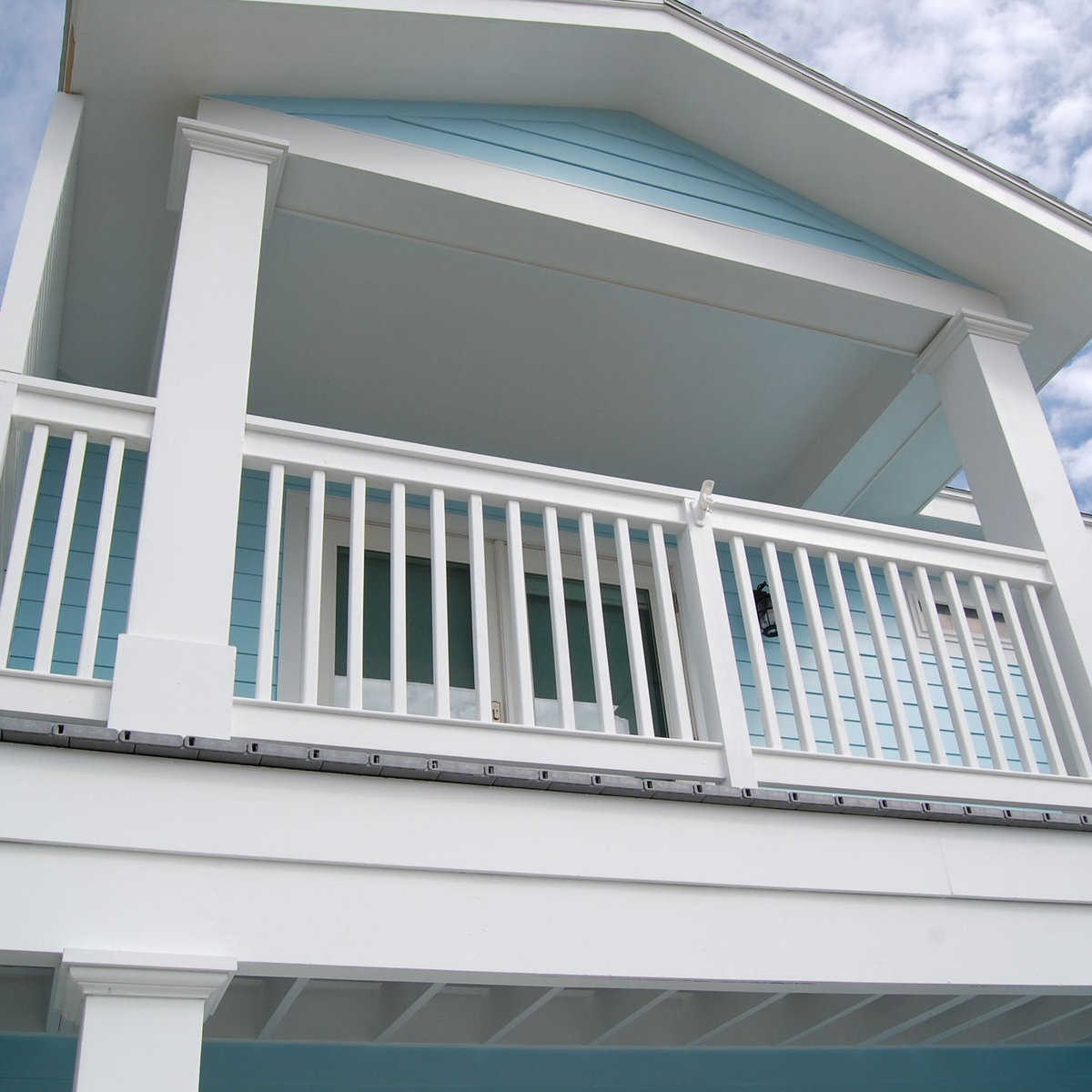 Coastal balcony with white railings and turquoise accents