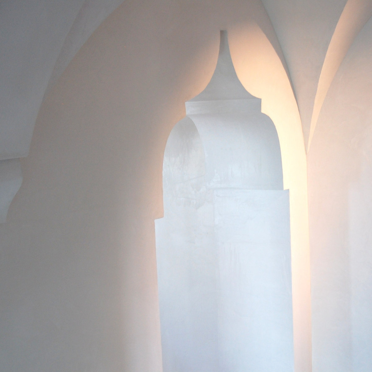 Curved white plaster archway with architectural detail