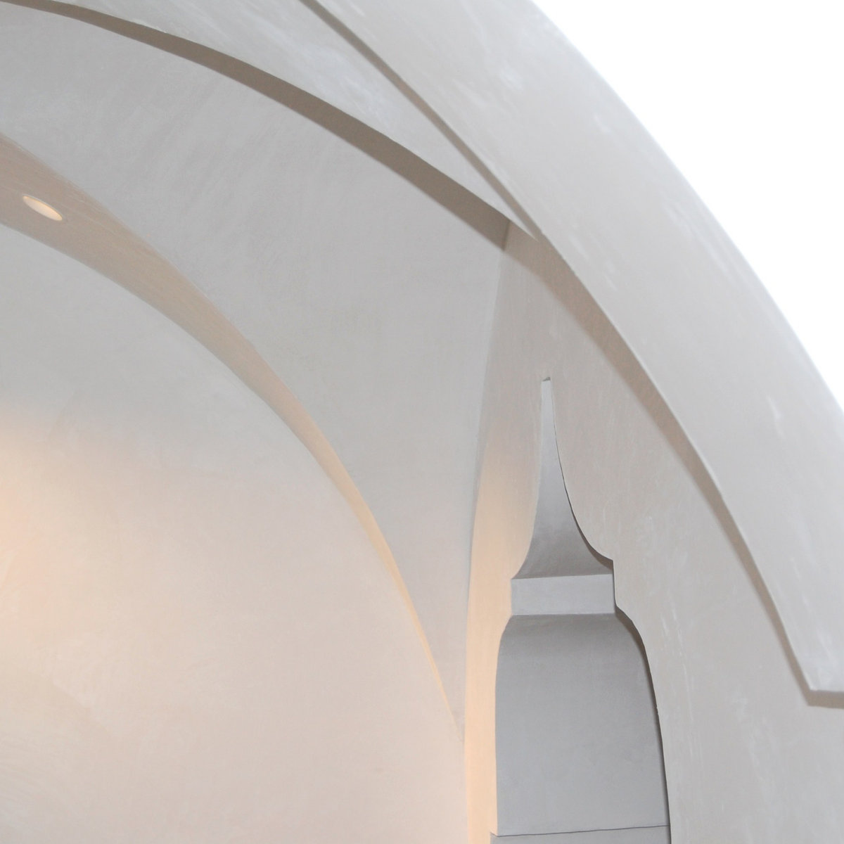Elegant curved white plaster archway detail