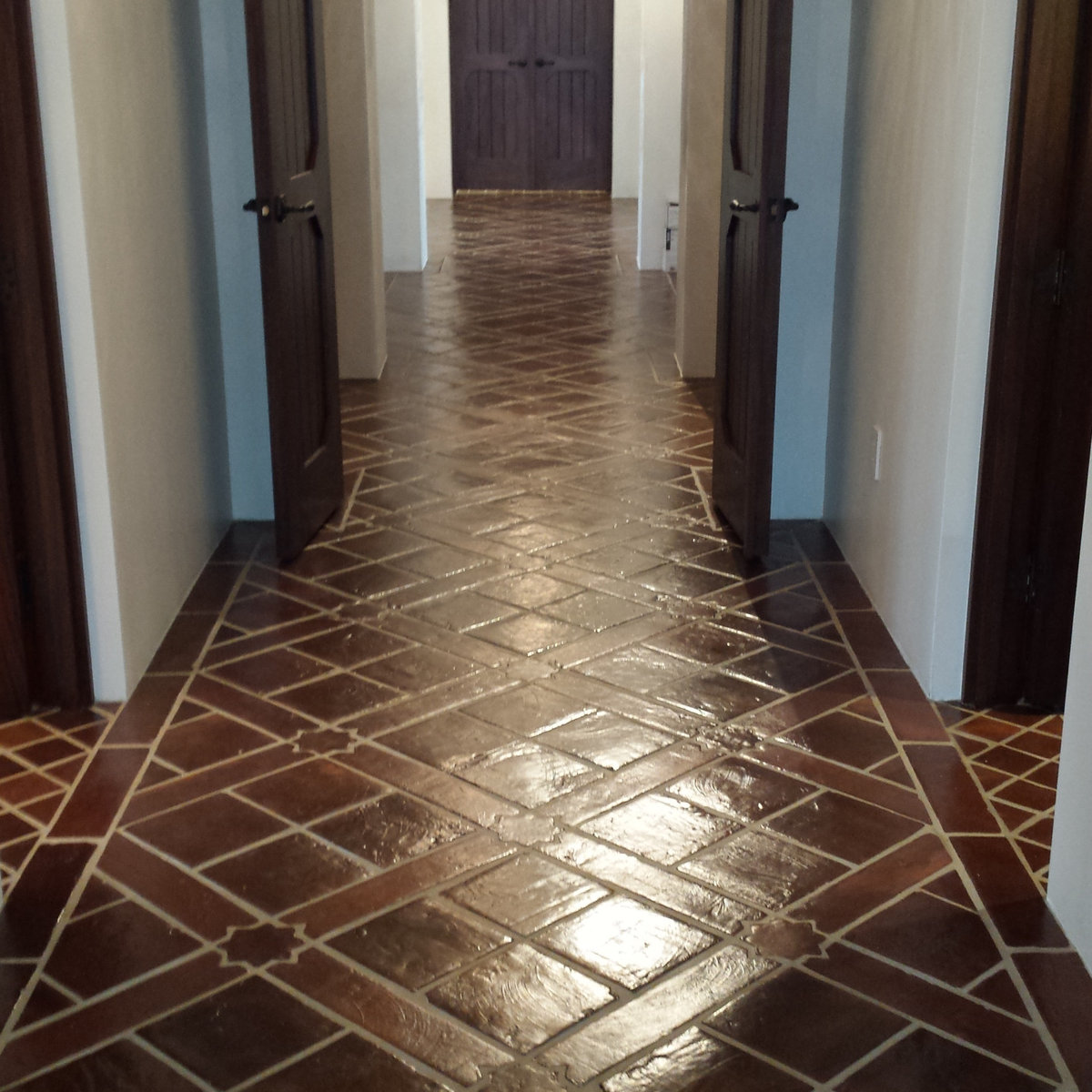Hallway with geometric patterned tile and dark wood doors