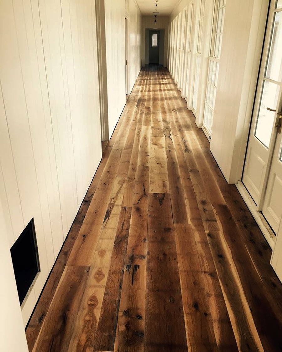 Hallway with reclaimed hardwood and shiplap walls