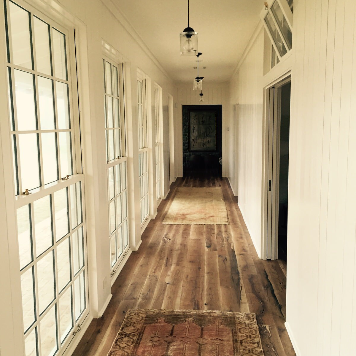 Bright hallway with shiplap walls and pendant lights
