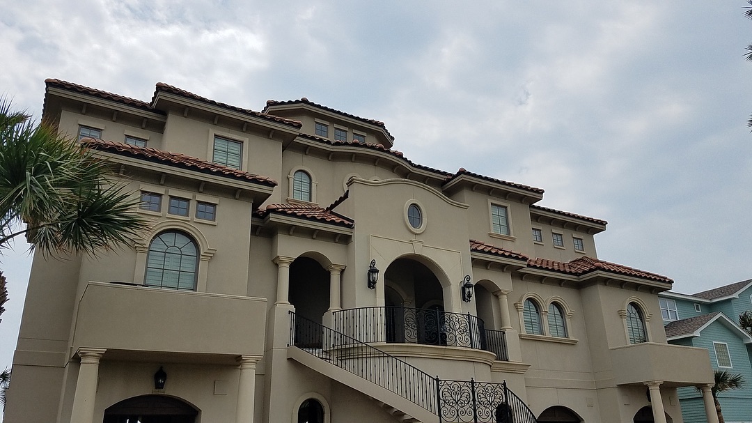 Mediterranean coastal home with stucco and arched details