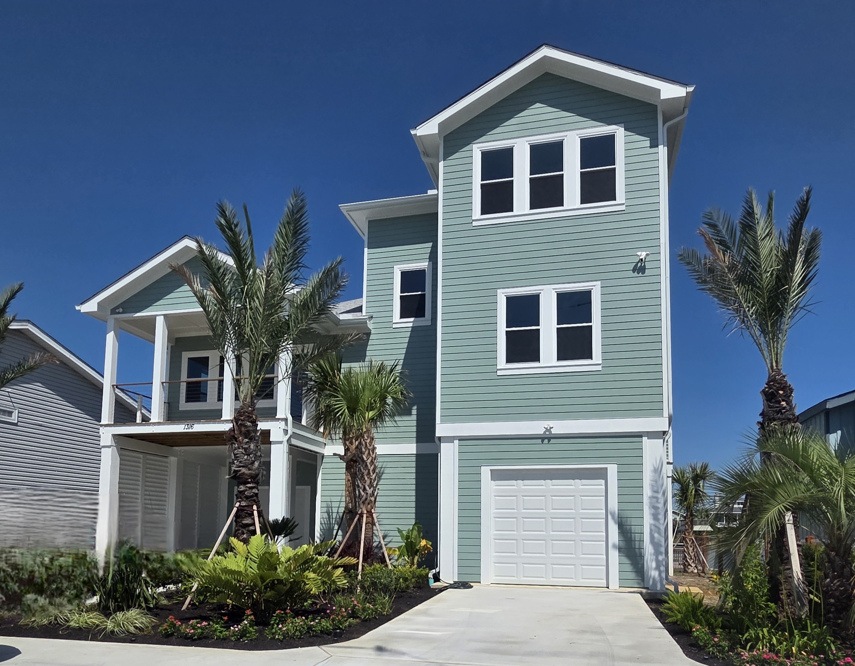 Mint green coastal home with palm trees