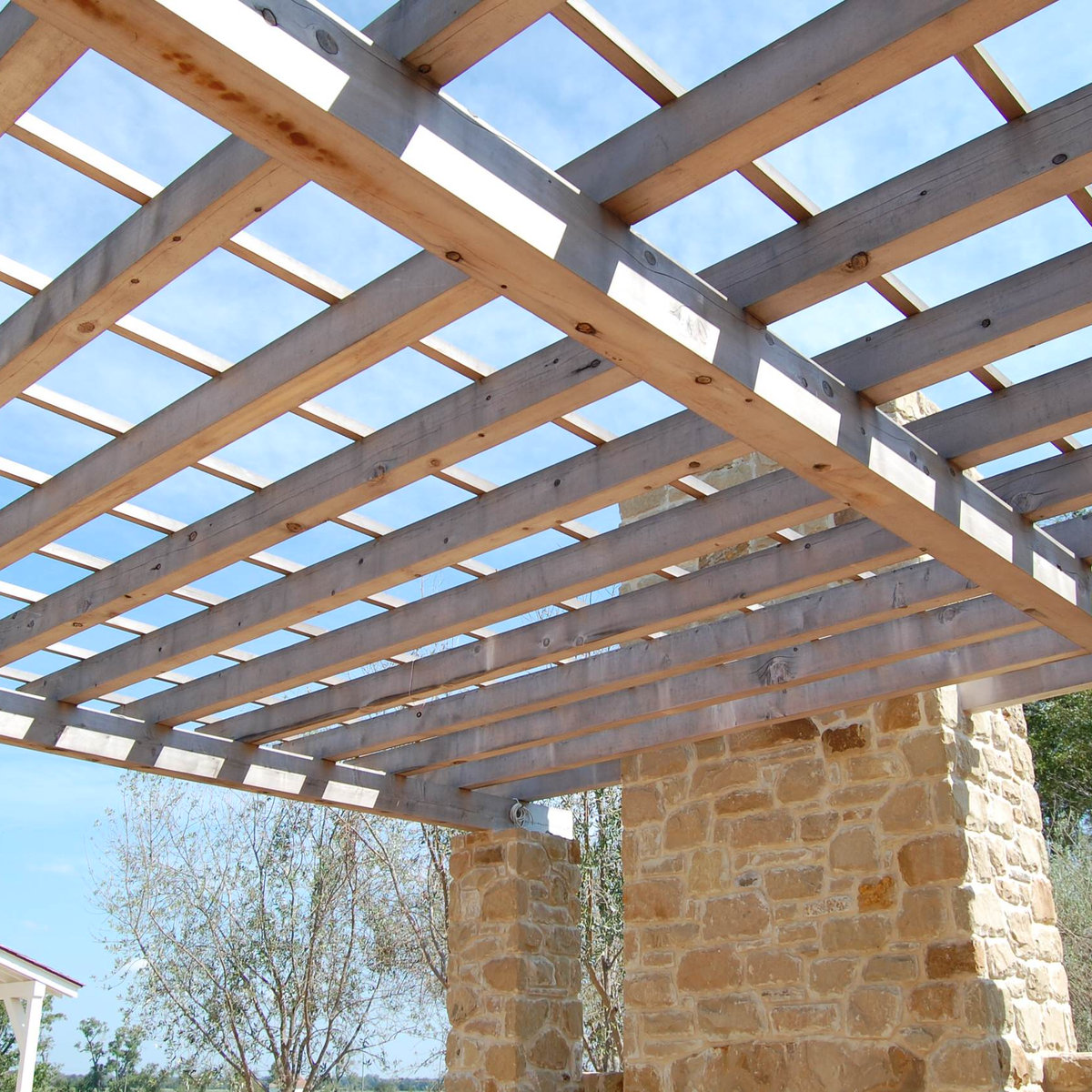 Wooden pergola with stone column supports