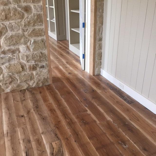 Interior with exposed stone wall and hardwood flooring