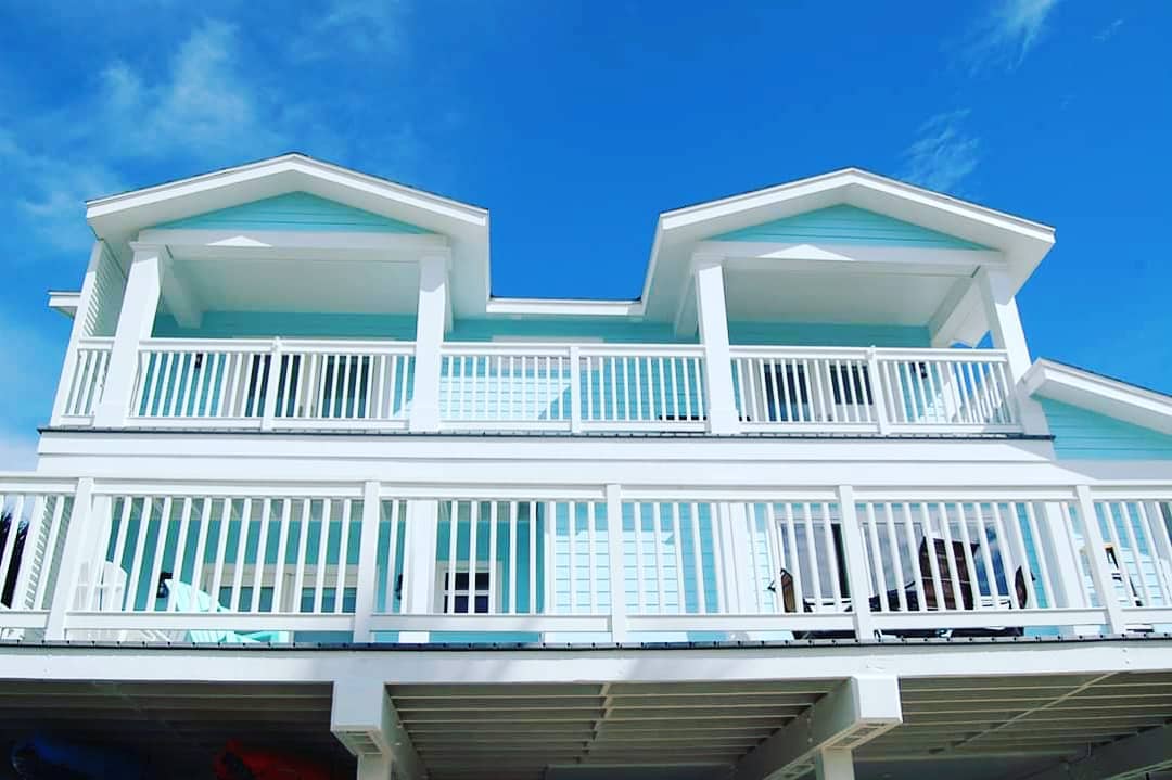 Three-story coastal home with turquoise accents and balconies