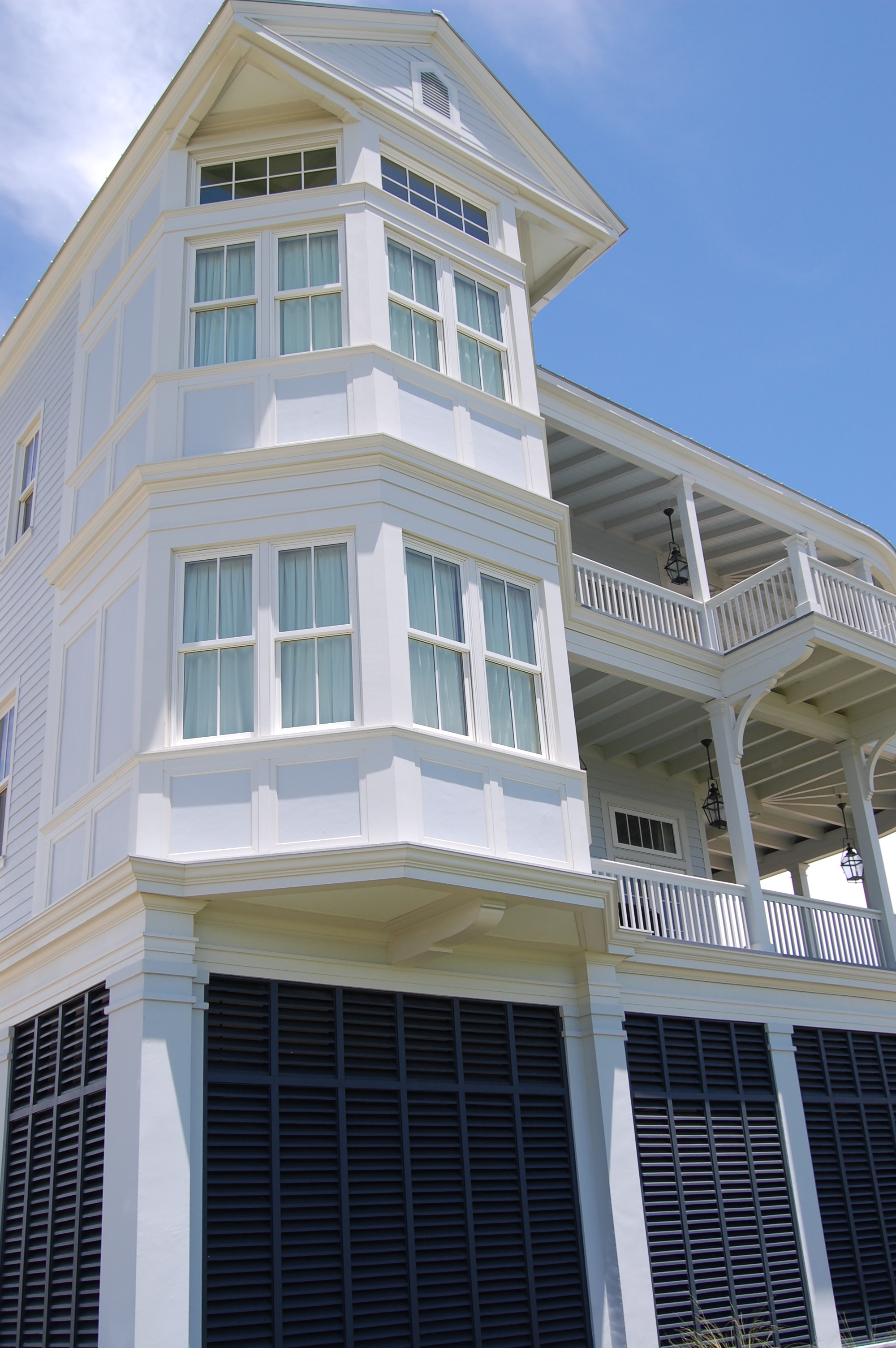 White multi-story coastal home with bay windows