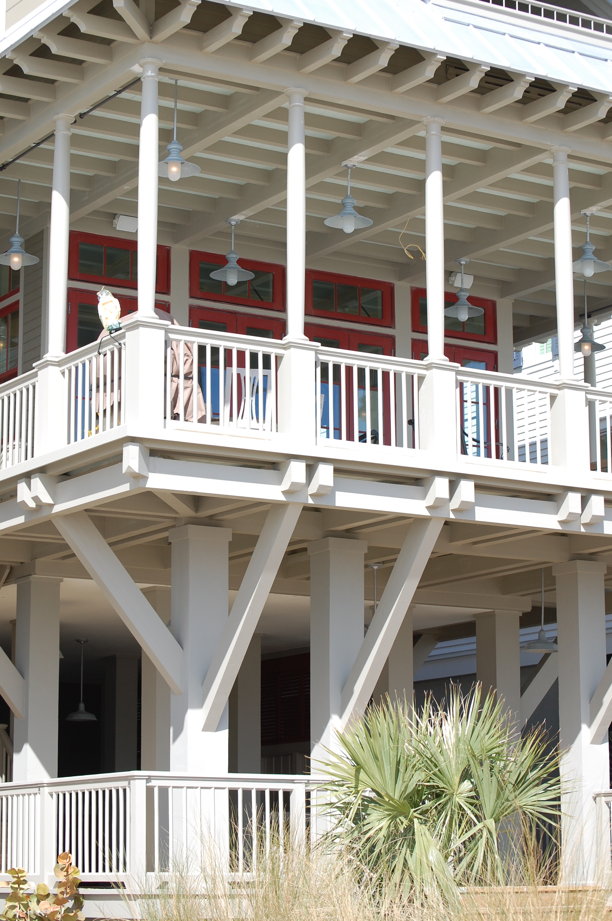 White coastal home with red accents and covered porches