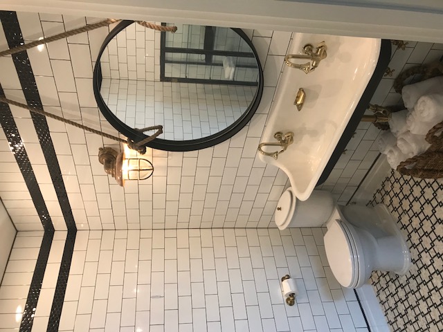 Nautical bathroom with subway tile and rope mirror