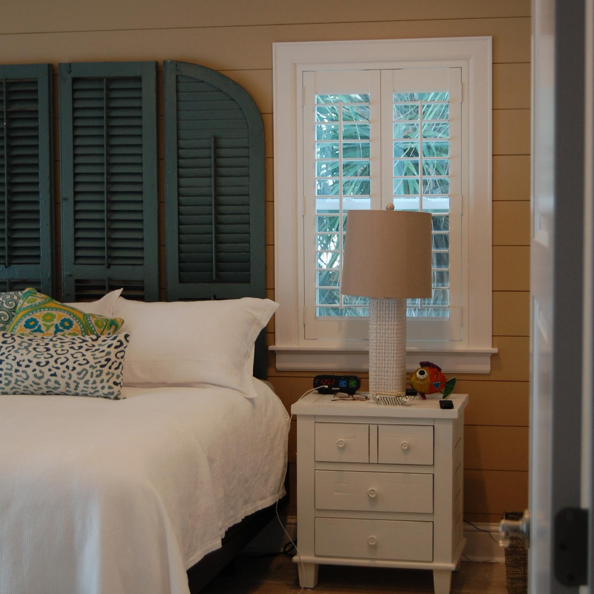 Coastal bedroom with shiplap walls and shutter headboard