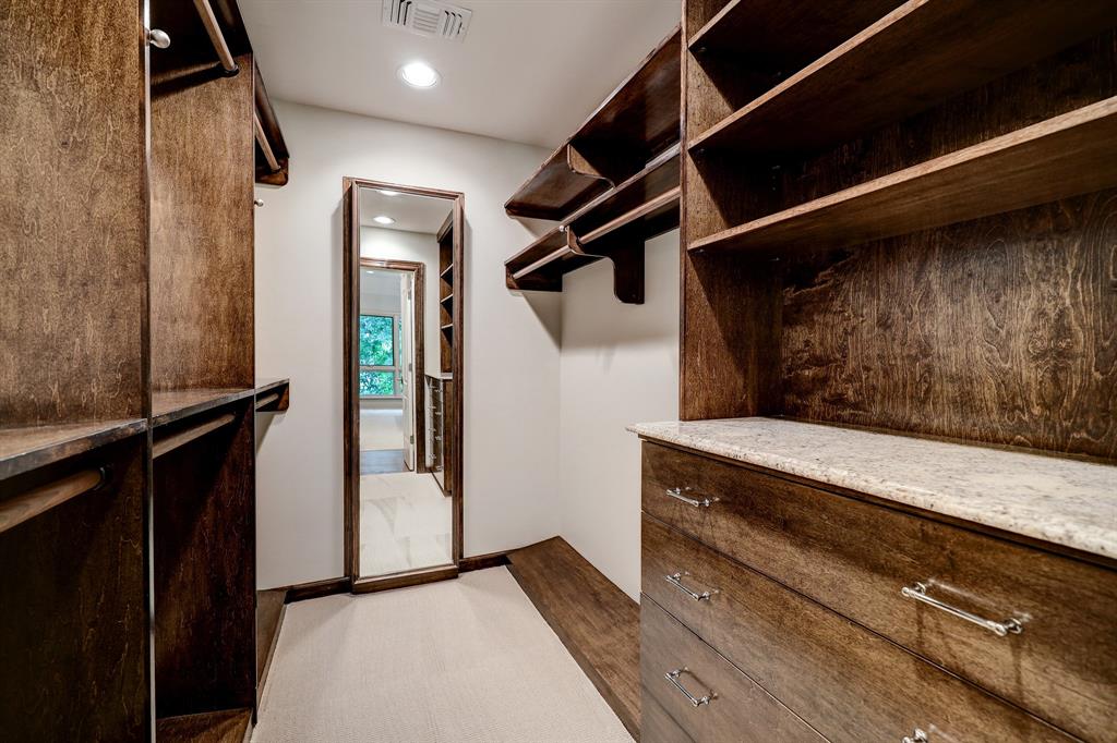 Custom walk-in closet with dark wood cabinetry