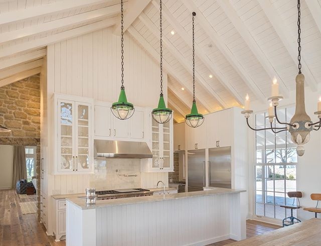 White farmhouse kitchen with green pendant lights