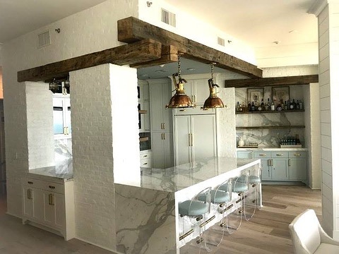Kitchen with marble waterfall island and wood beam accents