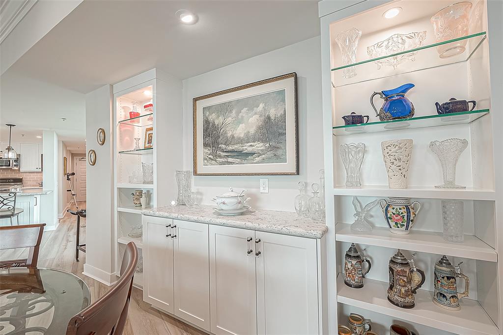 Built-in white buffet cabinetry with glass shelves